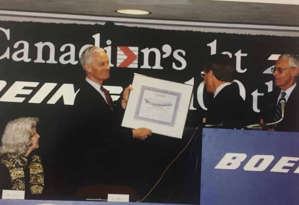 A Boeing exec presents a delivery certificate to Rhys Eyton. This was the special handover ceremony of Canadian Airlines' first Boeing 747-475 "Maxwell Ward" at Boeing Field, December 13, 1990, prior to delivery to Vancouver.